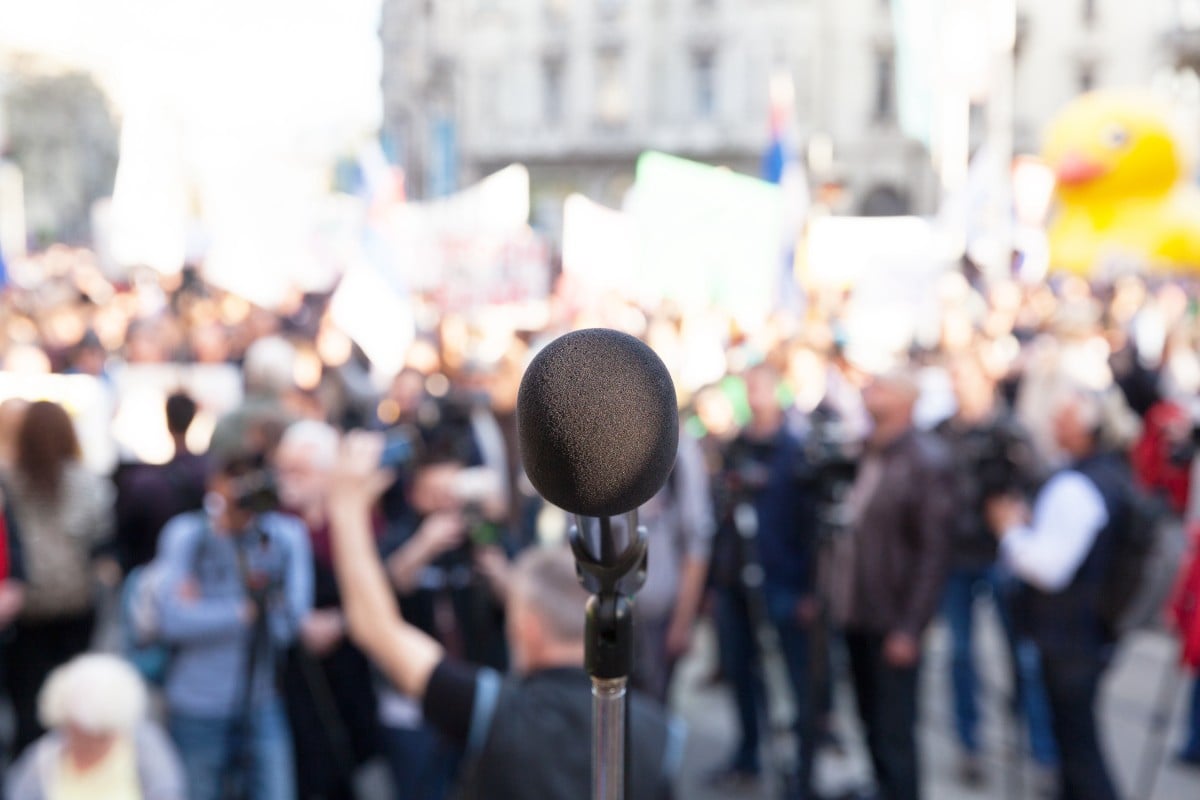 Microphone in front of a crowd of press and protestors 149747993