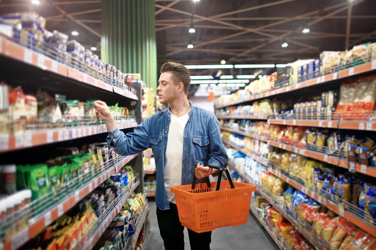 young white man shops in store aisle for health and wellness products