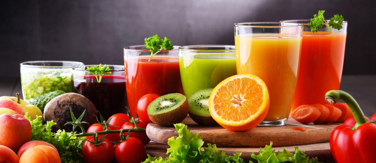 assortment of fruit juices and with fresh fruits in forefront 347566970