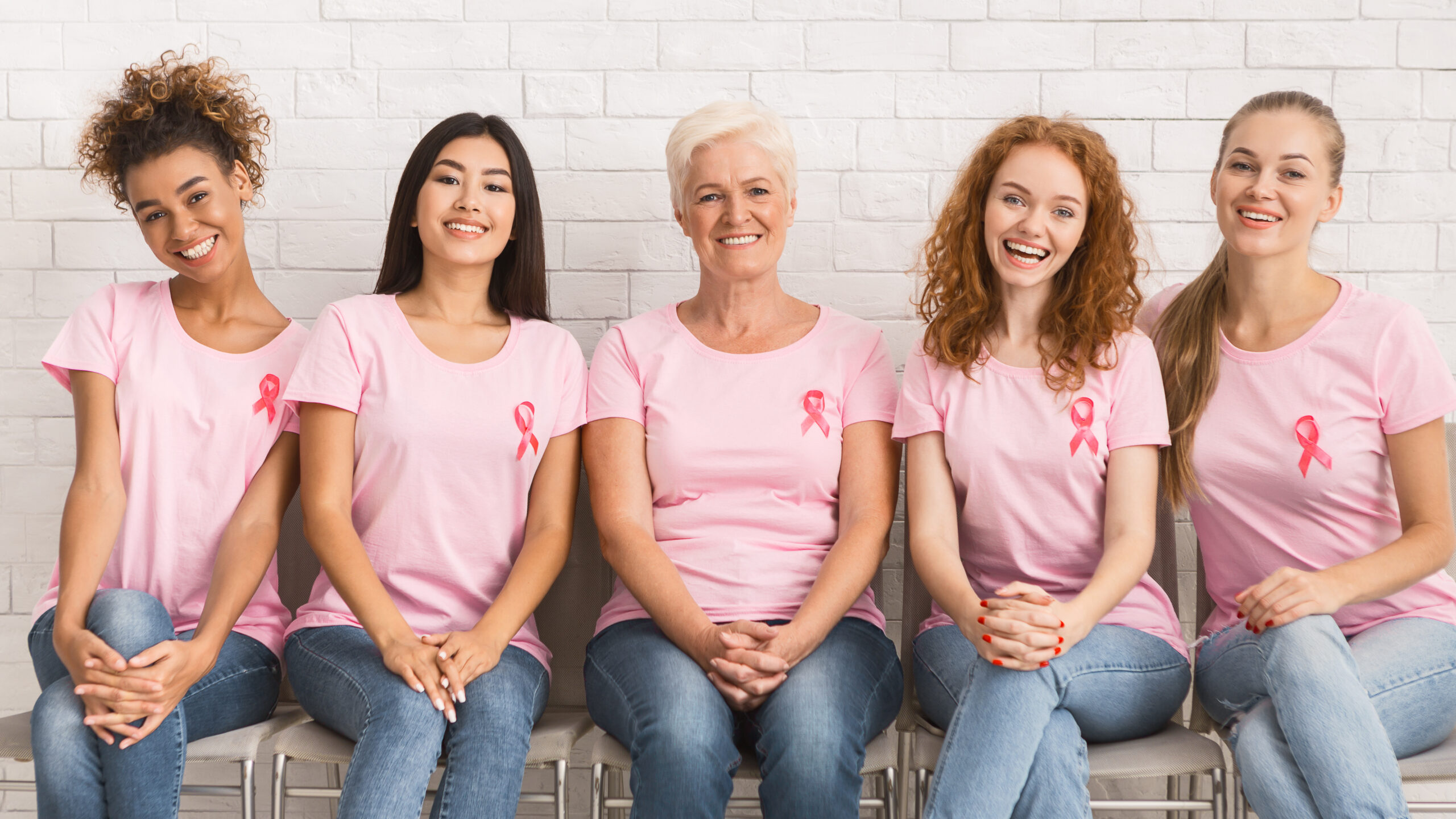 Five women in a pink t-shirt with breast cancer symbol