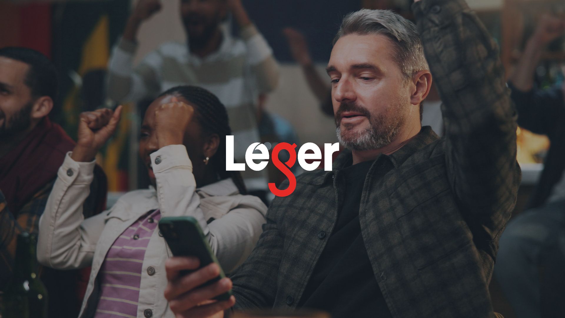 Paris Sportifs 2026 Victoire, homme et célébration avec téléphone au pub pour regarder le match en streaming, un but ou soutenir son équipe. Fans de foot, adultes ou application mobile au bar pour suivre le score, les résultats en direct ou organiser une soirée foot.